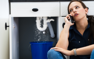woman collecting leaking water in bucket and calling plumber